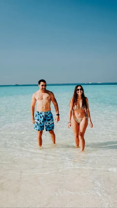 Couple wading in the clear water of a Komodo white sand beach
