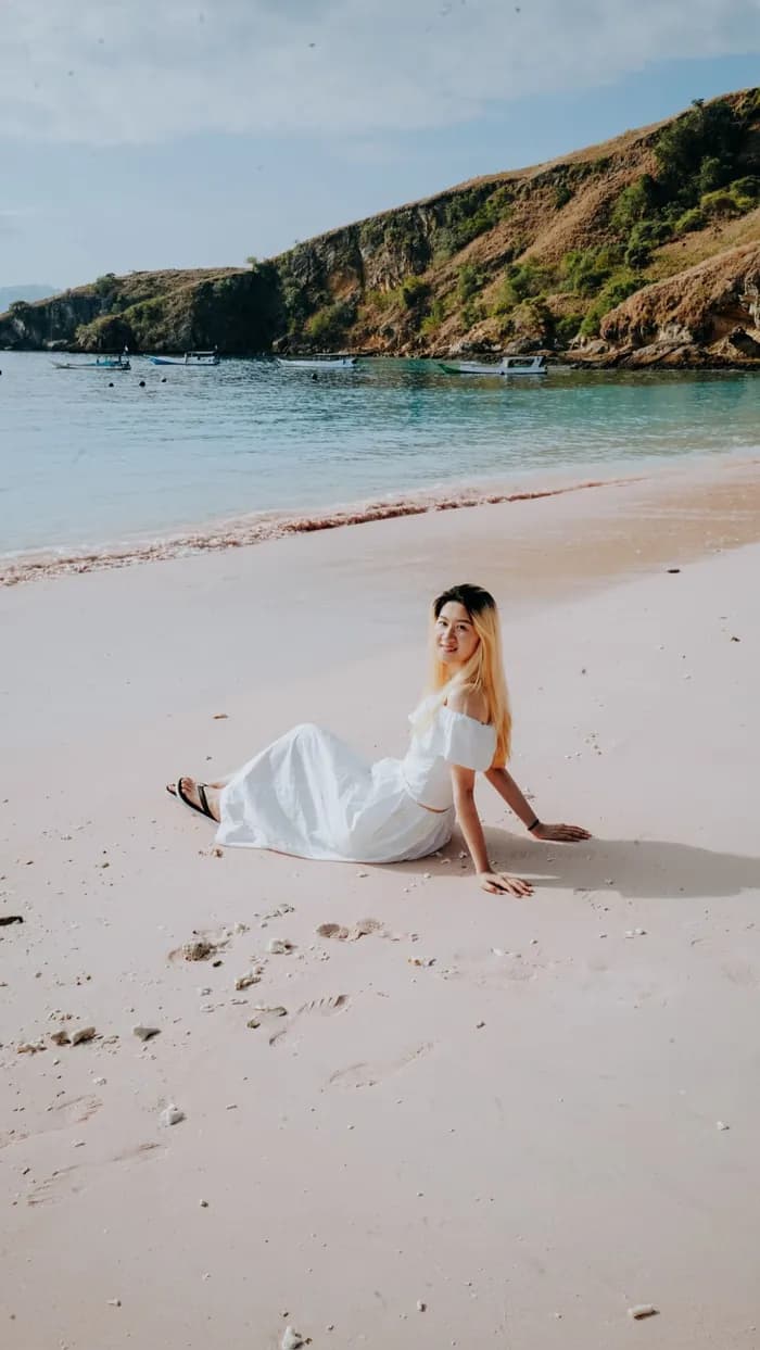 Traveler in a white dress on the pink sands of Pink Beach, Komodo National Park